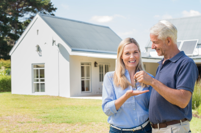 senior couple standing outside the house